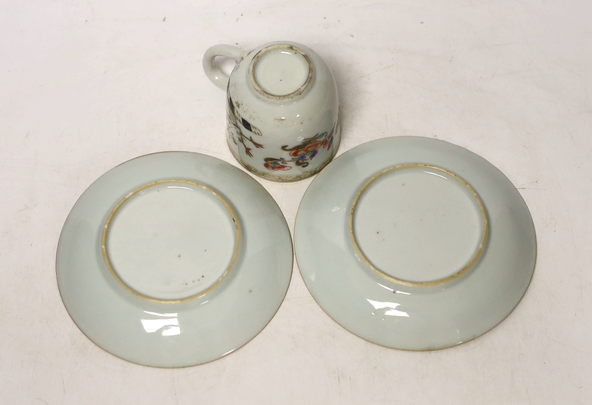 A Chinese armorial coffee cup and two saucers, saucers 12cm in diameter